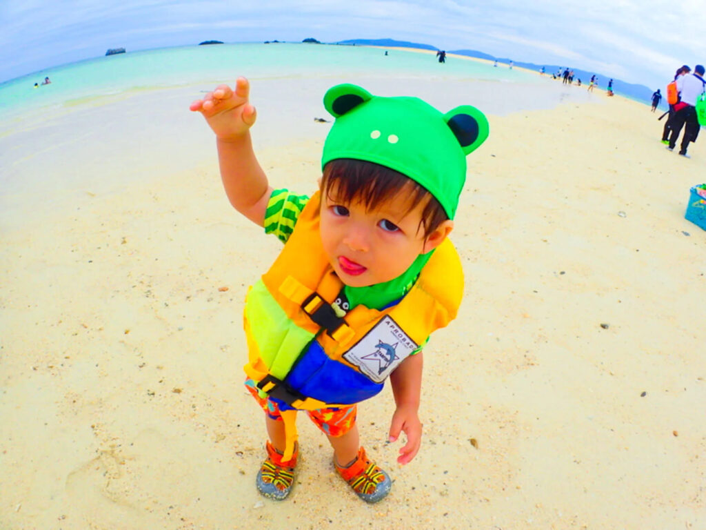 2歳くらいの子供が幻の島でポージング。しっかりライフジャケットを付けています