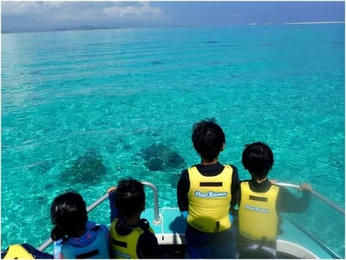 子供達が船の先端から景色を眺めています。